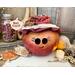 This is a fall apple decoration. It is a real gourd with a happy face  carved into it. This gourd is named Apple and has a lacy handmade hat